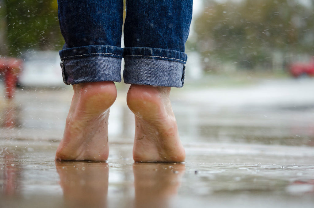 Bare feet standing in rain